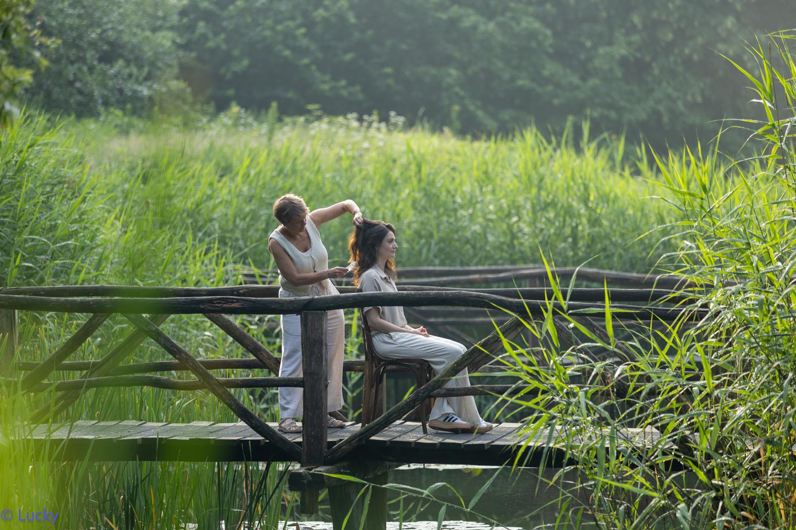 Kim werkt met aandacht aan het haar van een klant in de natuur